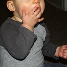 happy baby child eats itself with a spoon