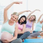 Pregnant asian woman doing yoga in the sea shore