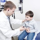 Doctor holding stethoscope to toddler boy's (18-21 months) chest