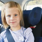 Three girls (6-8 years) sitting on rear seat of car during road trip