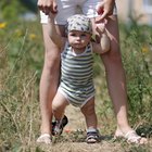 Mother and father teaching baby to walk