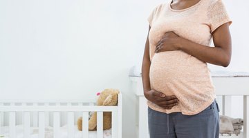 Pregnant woman eating strawberries on sofa