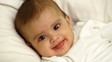 Young happy family with nurse looking down at their newborn in the hospital nursery
