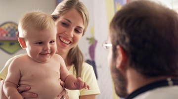 Side profile of a female doctor examining a baby boy with a stethoscope