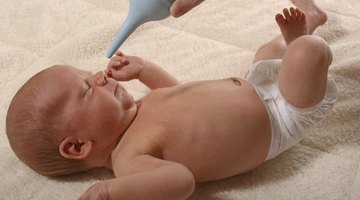 Close-up of a baby boy holding the railing of a crib