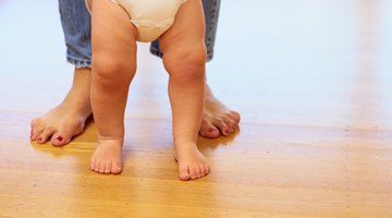 Hispanic mother helping baby walk