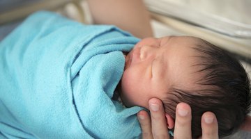 Small baby with mother on bed