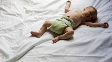 Close-up of a baby boy holding the railing of a crib