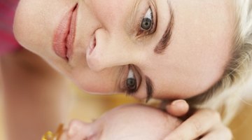 Mother feeding infant girl with a milk bottle