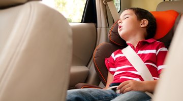 Three girls (6-8 years) sitting on rear seat of car during road trip
