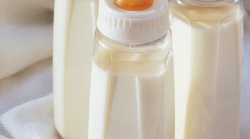 baby with small bottle in bed