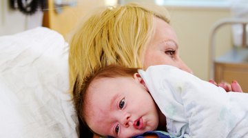 Close-up of a baby boy holding the railing of a crib