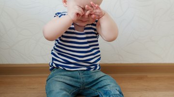 woman talking on the telephone and looking at thermometer while boy (10-12) sleeps in bed