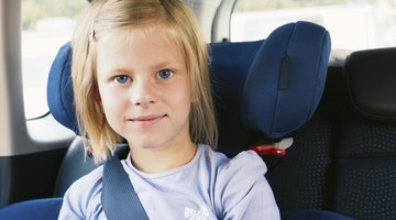 Three girls (6-8 years) sitting on rear seat of car during road trip