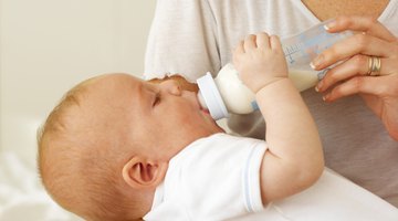 Woman feeding hungry baby with bottle