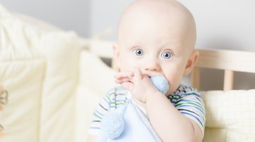 Closeup of caring mother holding head on sick daughter forehead