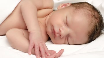 Close-up of a baby boy holding the railing of a crib