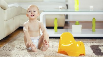Female baby (6-9 months) crawling towards camera as another baby playing behind
