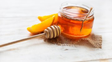 close-up of a honey dipper over a bowl of cereal