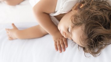 little girl in her bed has a stomachache