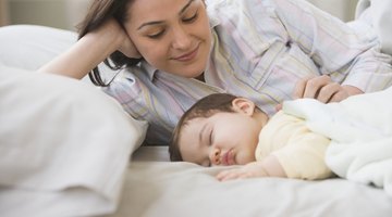 Cute sleeping newborn baby child on mother hands