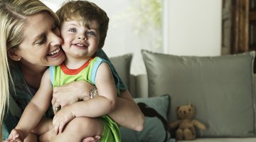 Father carrying baby daughter (15-18 months) outdoors, close-up