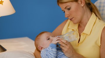 Woman feeding hungry baby with bottle