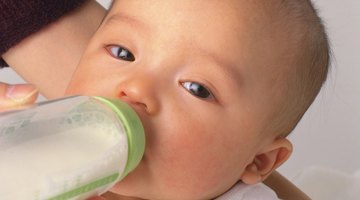 young mother breast feeding her baby girl at sunny day