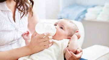 young mother breast feeding her baby girl at sunny day