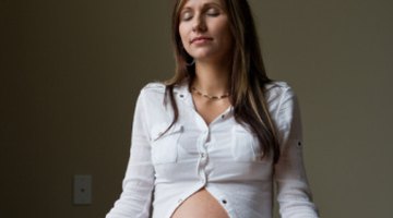 Belly of pregnant woman in sunset lights