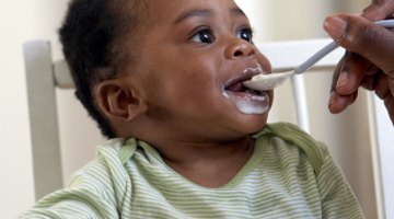 Portrait of young woman feeding her baby